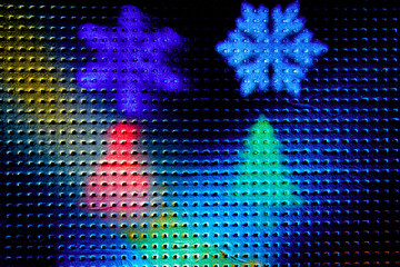 Two rays of light on a black background. Colored snowflakes and christmas trees
