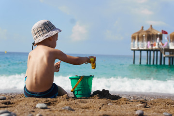 toddler child playing on sand beach on summer holidays, turkey beach, summer holidays at sea