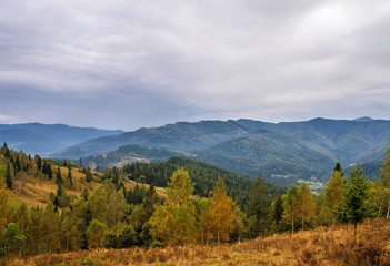 Beautiful autumn mountain forest landscape. Clouds over the rocks.