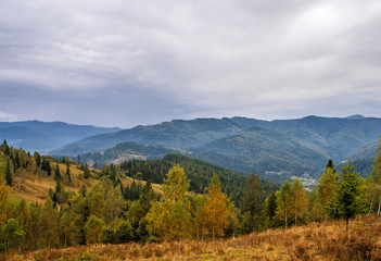 Fototapeta na wymiar Beautiful autumn mountain forest landscape. Clouds over the rocks.