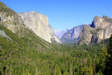 Fototapeta premium Tunnel View provides one of the most famous views of Yosemite Valley, from here you can see El Capitan and Bridalveil Fall rising from Yosemite Valley, with Half Dome in the background. .