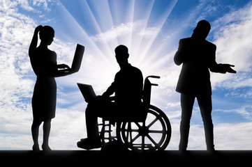 Disabled worker in a wheelchair with a laptop and his work team