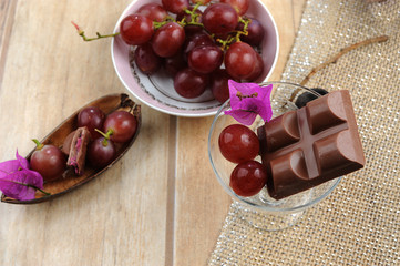 Artisanal chocolate, Brazilian.Grape flavor.Jute napkin background, light wood. Close view.