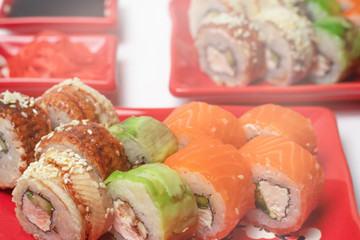 delicious sushi and rolls on a red plate on a white background. traditional Japanese cuisine
