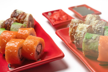 delicious sushi and rolls on a red plate on a white background. traditional Japanese cuisine