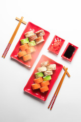 delicious sushi and rolls on a red plate on a white background. traditional Japanese cuisine