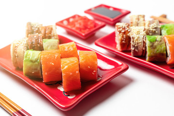 delicious sushi and rolls on a red plate on a white background. traditional Japanese cuisine