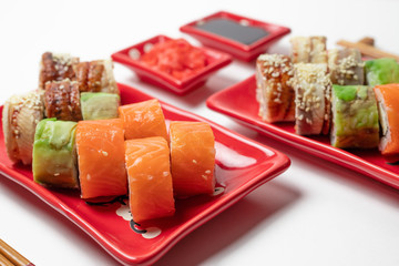delicious sushi and rolls on a red plate on a white background. traditional Japanese cuisine
