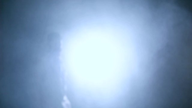 Medico che cammina al rallentatore di fronte la telecamera con sfondo di fumo