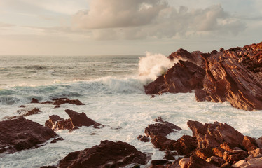 coastal cliffs by the ocean with waves. sunset.