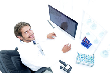 view from above of the scientist-doctor sitting on the computer.