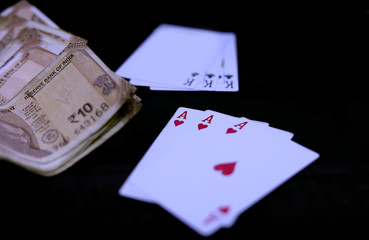 Playing Cards and Indian Currency Rupee bank notes on black background