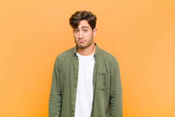 young handsome man feeling sad and stressed, upset because of a bad surprise, with a negative,...