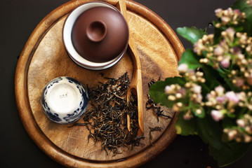 Tea scattered on the table with Chinese dishes and flowers