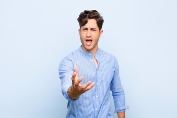 young handsome man looking angry, annoyed and frustrated screaming wtf or what‚Äôs wrong with...