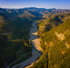 Big river valley surrounded by mountains during sunset 