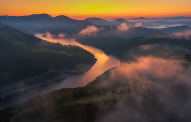 River valley during magical sunrise with clouds 