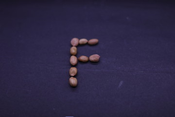 "F" Text made of Peanuts. Peanuts in the form of a Text isolated on white Background. Natural Protein from Peanuts.