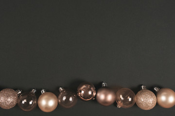 Golden christmas balls on a black background with space for text. Top view. Flat lay
