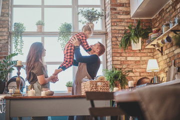 Fototapeta premium Nice small family are together at the kitchen, they planning to cook something.