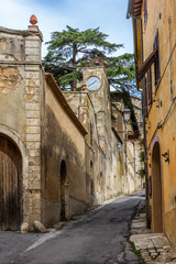 The old clock tower and the colorful narrow streets in the medieval town of Massa Marittima in Tuscany