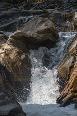 The flow of water between stones in a mountain river