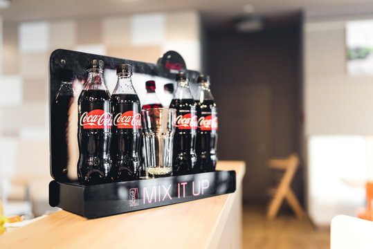 Classic Coca-Cola bottles standing at the bar, placed in Coca-Cola advertising black stand. Hotel Boutique, Katowice 22 May 2017. Poland. 