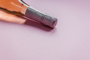 Bottle of rose champagne wine on pink background