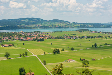 Obraz premium Panoramic view of riverland with green pastures and fields.