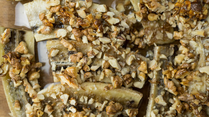 Banany z orzechami zapiekane w piecu. Zdrowy deser. Zbliżenie.