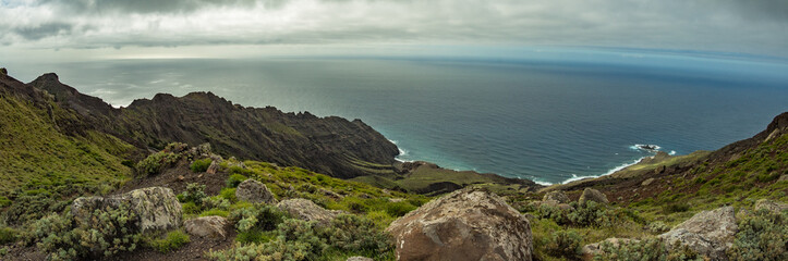 Fototapeta na wymiar Rocky coastline with sharp cliffs in the ocean on the North of La Gomera island near Arguamul village where you can get along the narrow winding serpatine. Canary Islands, Spain