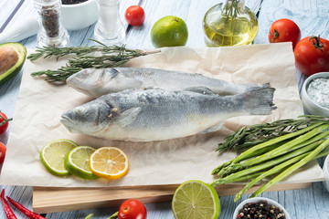 photo seafood and fish on parchment with vegetables on the Board