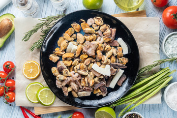photo seafood and fish on parchment with vegetables on the Board