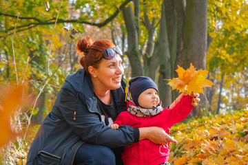 autumn.a mother and her child walking in autumn Park and smiling