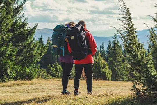 Girl and man hikers in mountains. Travel backpacks and clothing. Campaign. Ukrainian Carpathian Mountains. Traveling in Ukraine.