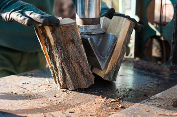 Man is using a electric saw for cutting firewood