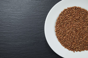 buckwheat in a white plate on a dark background