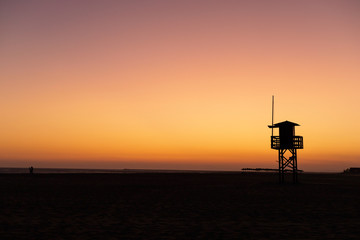 silhouette of the lifeguard house on the beach of Isla canela, at sunset. Huelva, Andalusia, Spain.