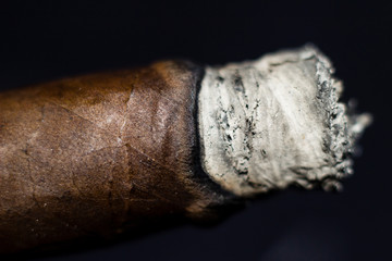 Close up of a Cuban cigar on a black background