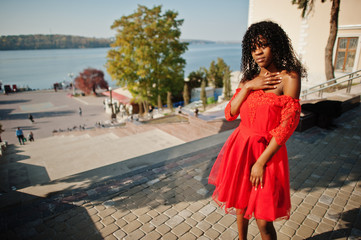 Stylish trendy afro france curly woman posed at autumn day in red dress. Black african female model.