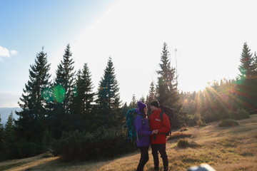 Fototapeta na wymiar Girl and man hikers in mountains. Travel backpacks and clothing. Campaign. Ukrainian Carpathian Mountains. Traveling in Ukraine.Couple
