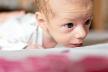 Lying on the bed sheet baby at home