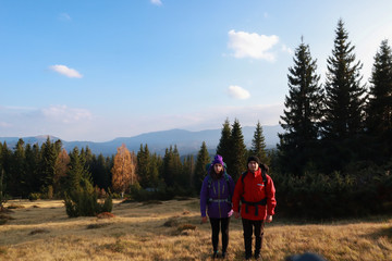 Girl and man hikers in mountains. Travel backpacks and clothing. Campaign. Ukrainian Carpathian Mountains. Traveling in Ukraine.Couple