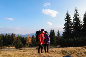 Fototapeta na wymiar Girl and man hikers in mountains. Travel backpacks and clothing. Campaign. Ukrainian Carpathian Mountains. Traveling in Ukraine.Couple