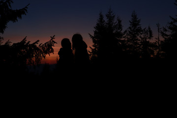 Silhouette of lesbian girls. Sunset. Autumn Carpathians in Ukraine. Travel.