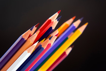 Colored pencils for drawing on a dark background.