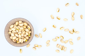 pistachios in shells in a bowl isolated on white background