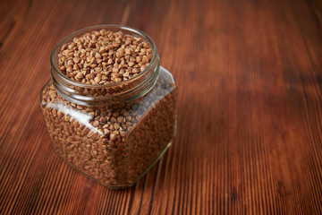 buckwheat in a jar closeup on a brown wood background