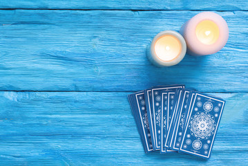 Blue tarot cards deck on blue wooden table flat lay background.