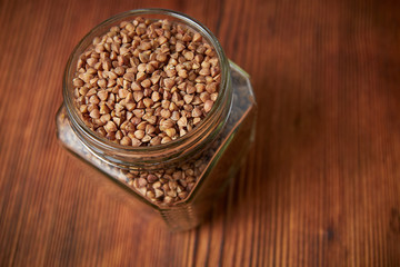 buckwheat in a jar closeup on a brown wood background